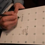 Person writing in a content planner notebook