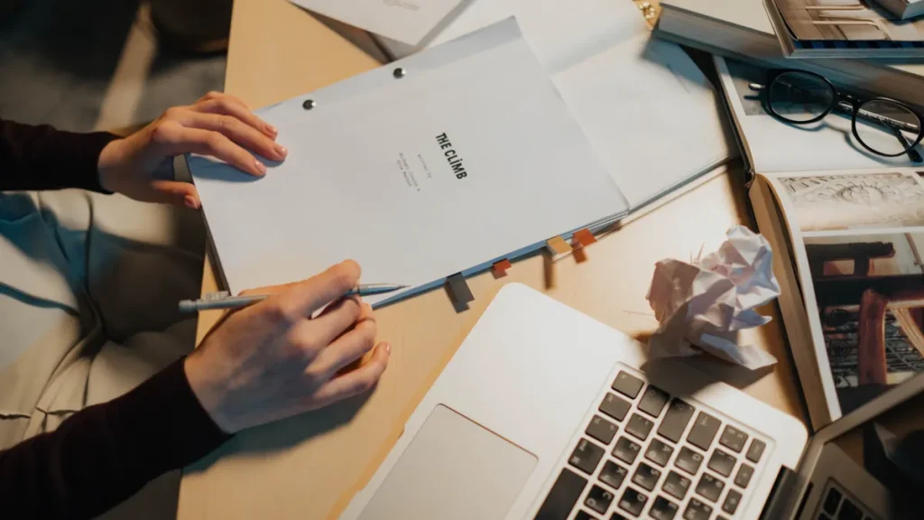 Hands holding a booklet labeled BRIEF beside a laptop