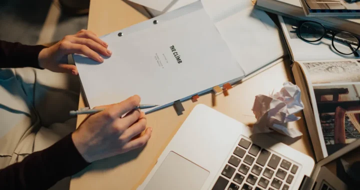 Hands holding a booklet labeled BRIEF beside a laptop